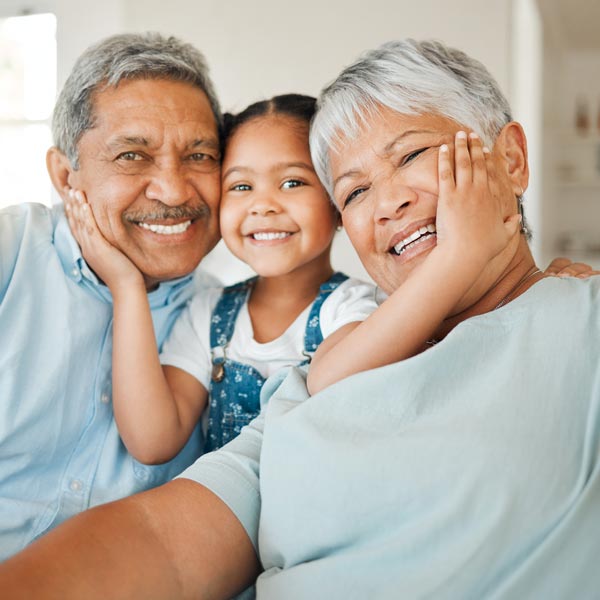 grandparents with granddaughter smiling